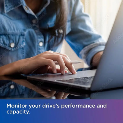 Person using a laptop with text about monitoring drive performance and capacity.