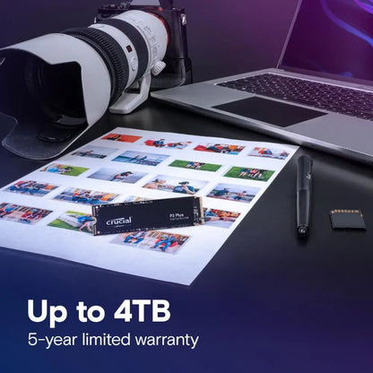 Camera, laptop, and memory card on a desk with promotional text for Crucial memory cards.
