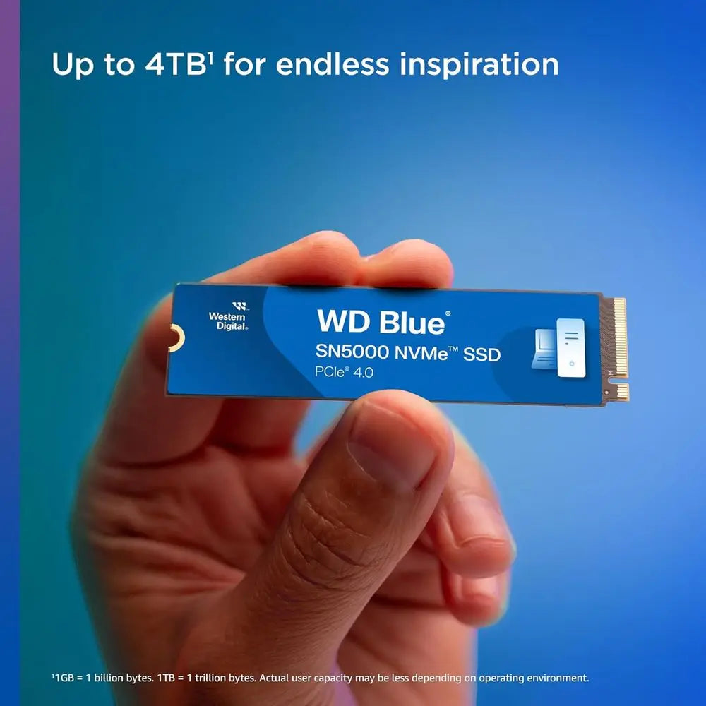 Hand holding a Western Digital Blue SN5000 NVMe SSD against a blue background